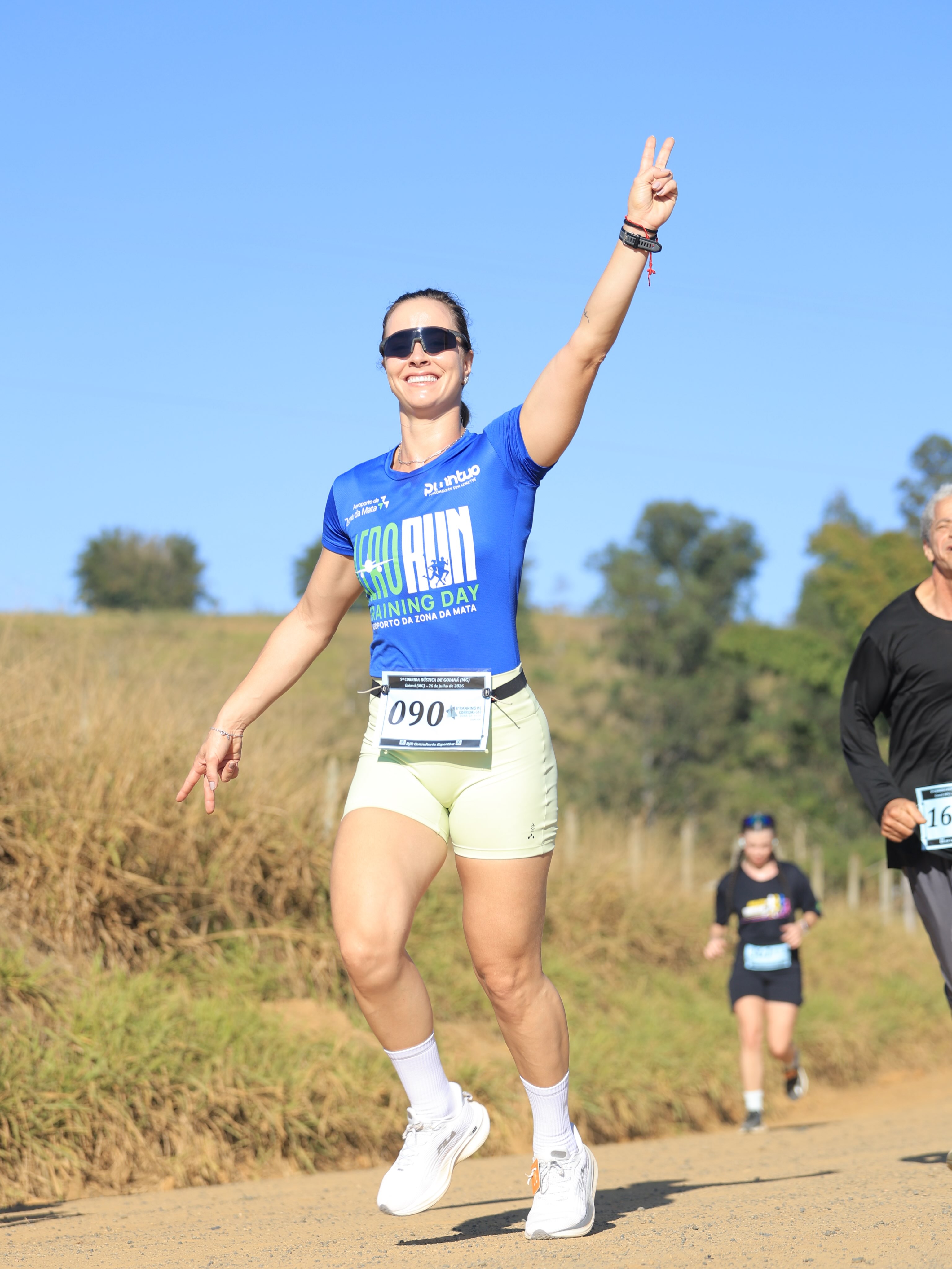 Atleta uniformizada pela Punntuo correndo com o braço erguido durante prova