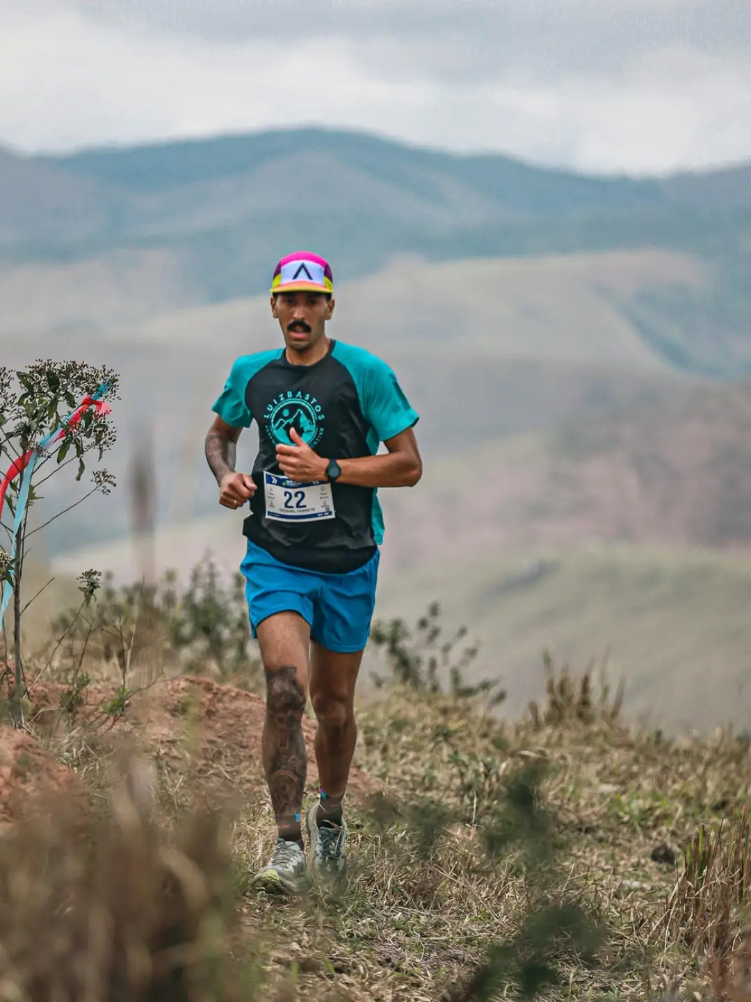 Atleta uniformizado pela Punntuo correndo em trilha de montanha